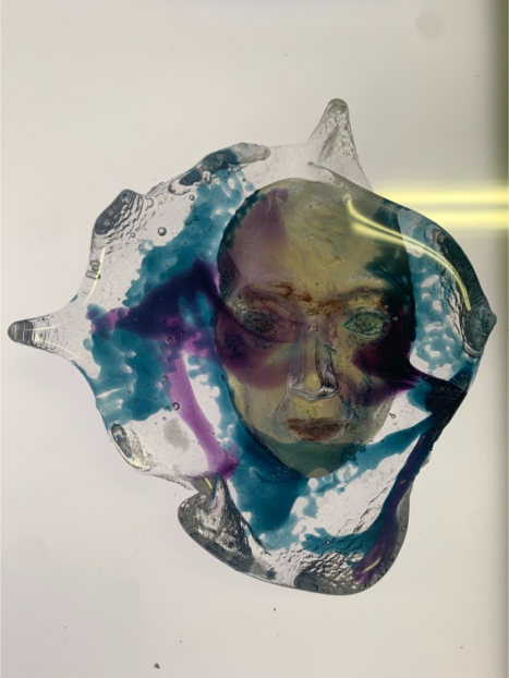 Glass piece with a face engraved inside