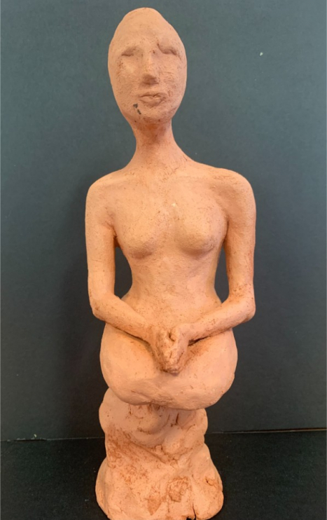 Abstract clay sculpture of a woman sitting down