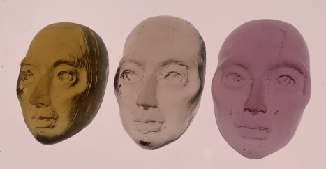 Three glass pieces in the shape of faces