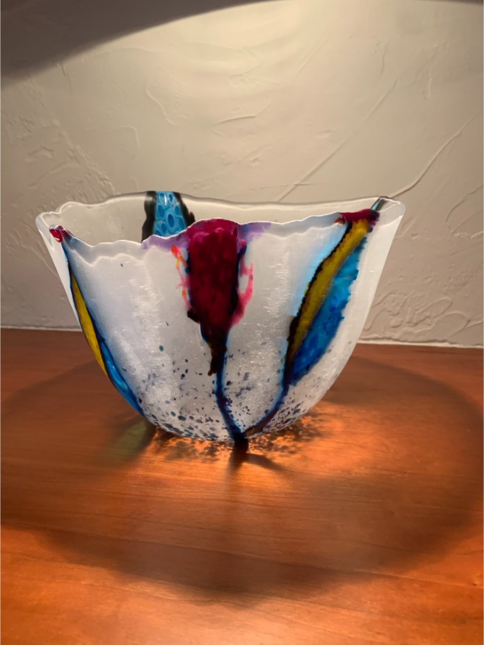 White glass bowl with colorful patches running up the side