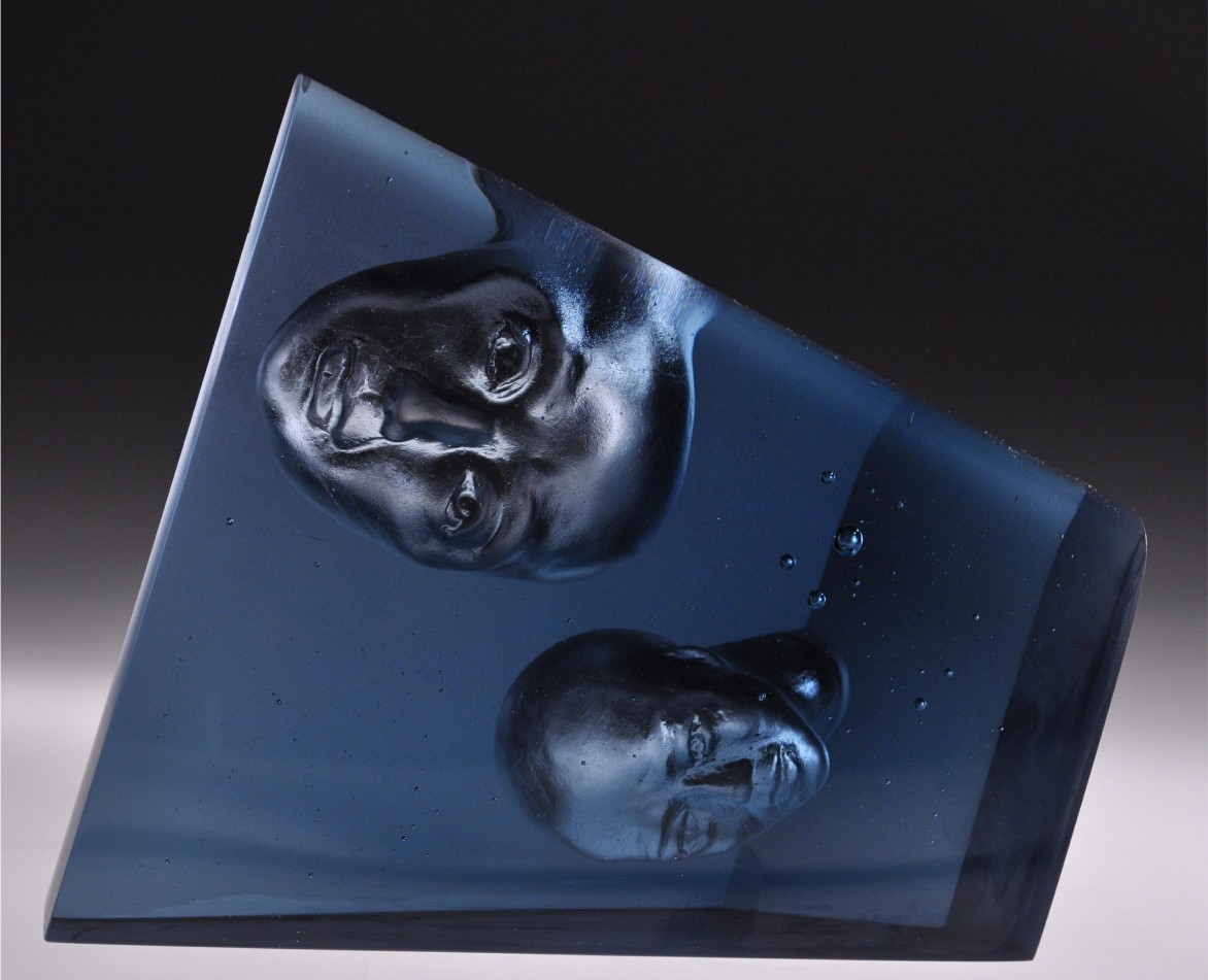 Glass piece with two heads engraved inside